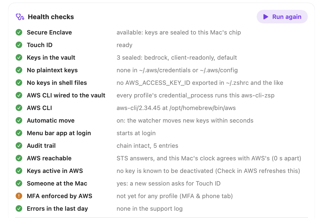 Health checks, all green except one: Secure Enclave, Touch ID, keys in the vault, no plaintext keys, no keys in shell files, AWS CLI wired to the vault, AWS CLI, automatic move, menu bar app at login, audit trail, AWS reachable, keys active in AWS, someone at the Mac, MFA enforced by AWS (a warning) and errors in the last day.